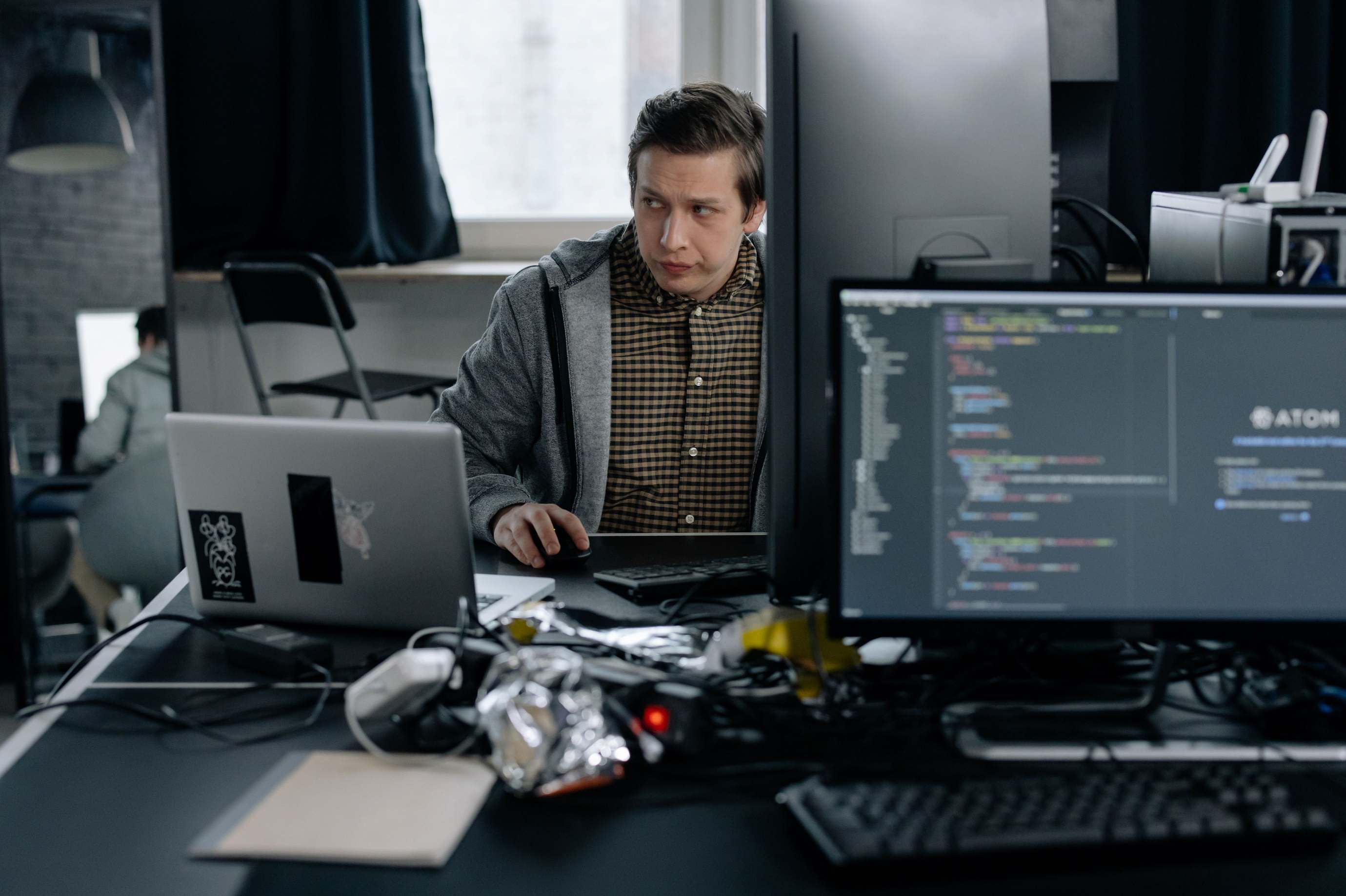 Laptop on a desk with code on screen in low light — computer code in a focused office